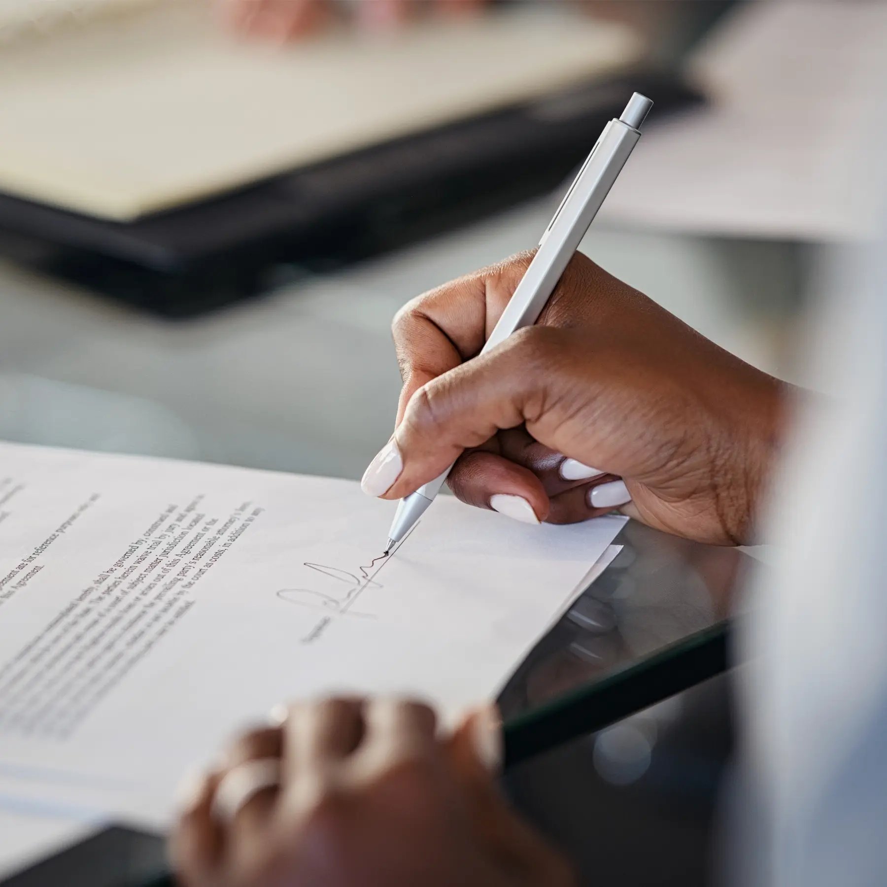 Close up of person signing paperwork