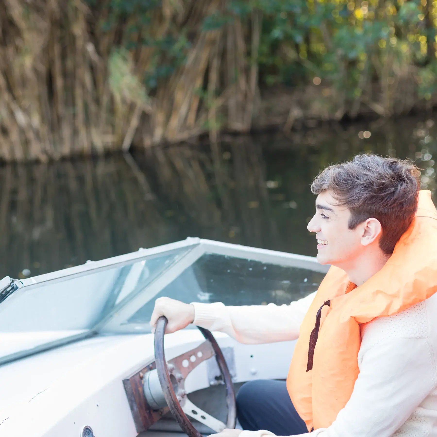smiling-young-man-wheel-boat