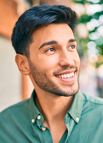 Young male smiles while thinking about his financial future