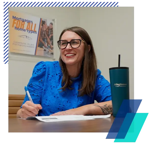 Christin signing loan paperwork for an Allegiance member