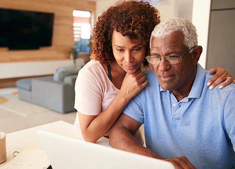 Senior couple reviewing financials on computer..