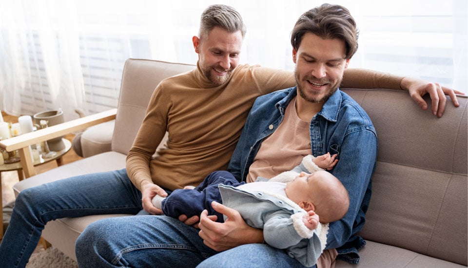 A personal loan calculator offers peace of mind like with these two fathers relaxing holding their son.