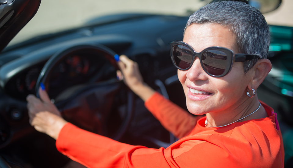 Guaranteed Asset Protection (GAP) protects your new car so you can smile worry free like this woman in sunglasses.