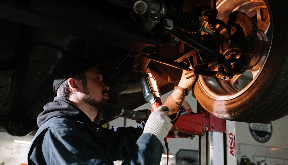 Extended car warranty helps cover this repair the mechanic is making to this car.