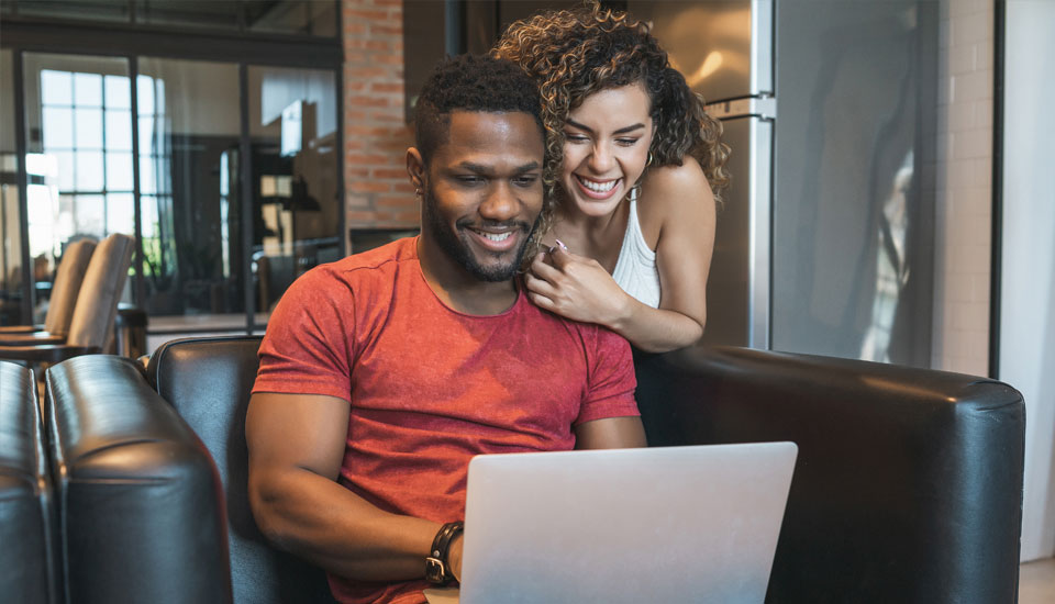 Couple reviewing their fico score on a laptop together trying to understand the difference between fico score vs credit score.