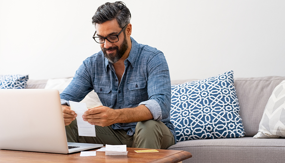 Man reviewing receipts and realizing how inflation affects his budget