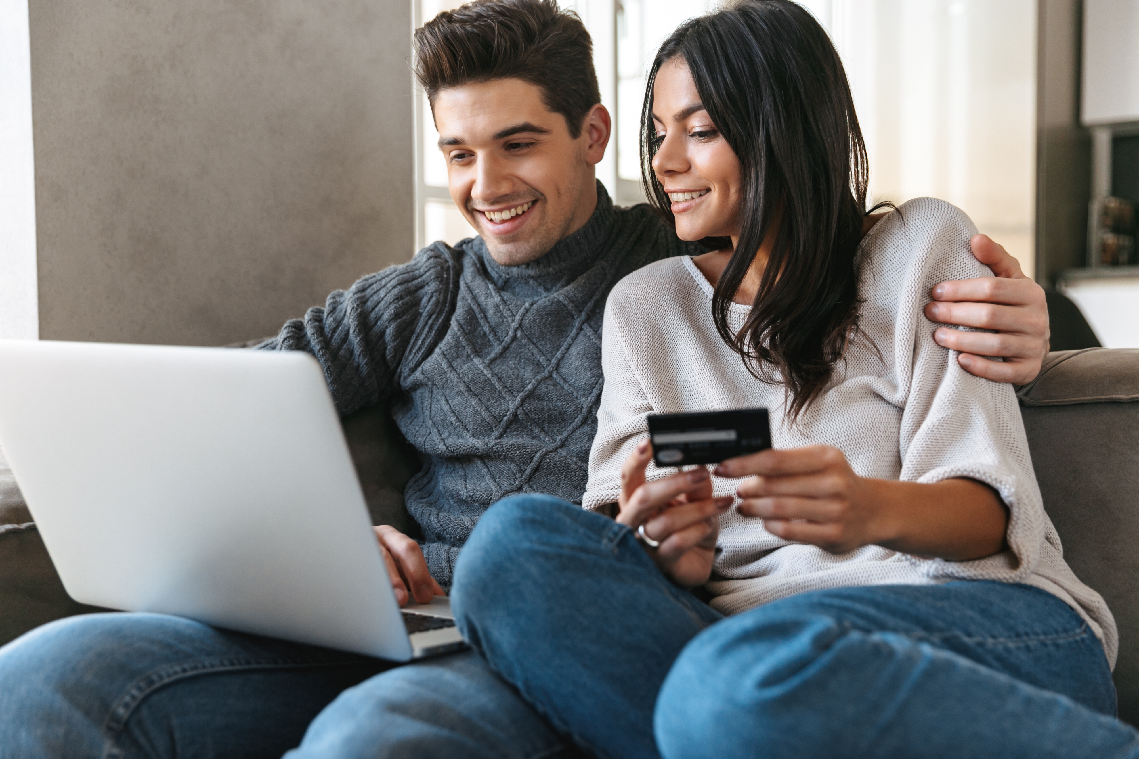 couple using laptop and credit card