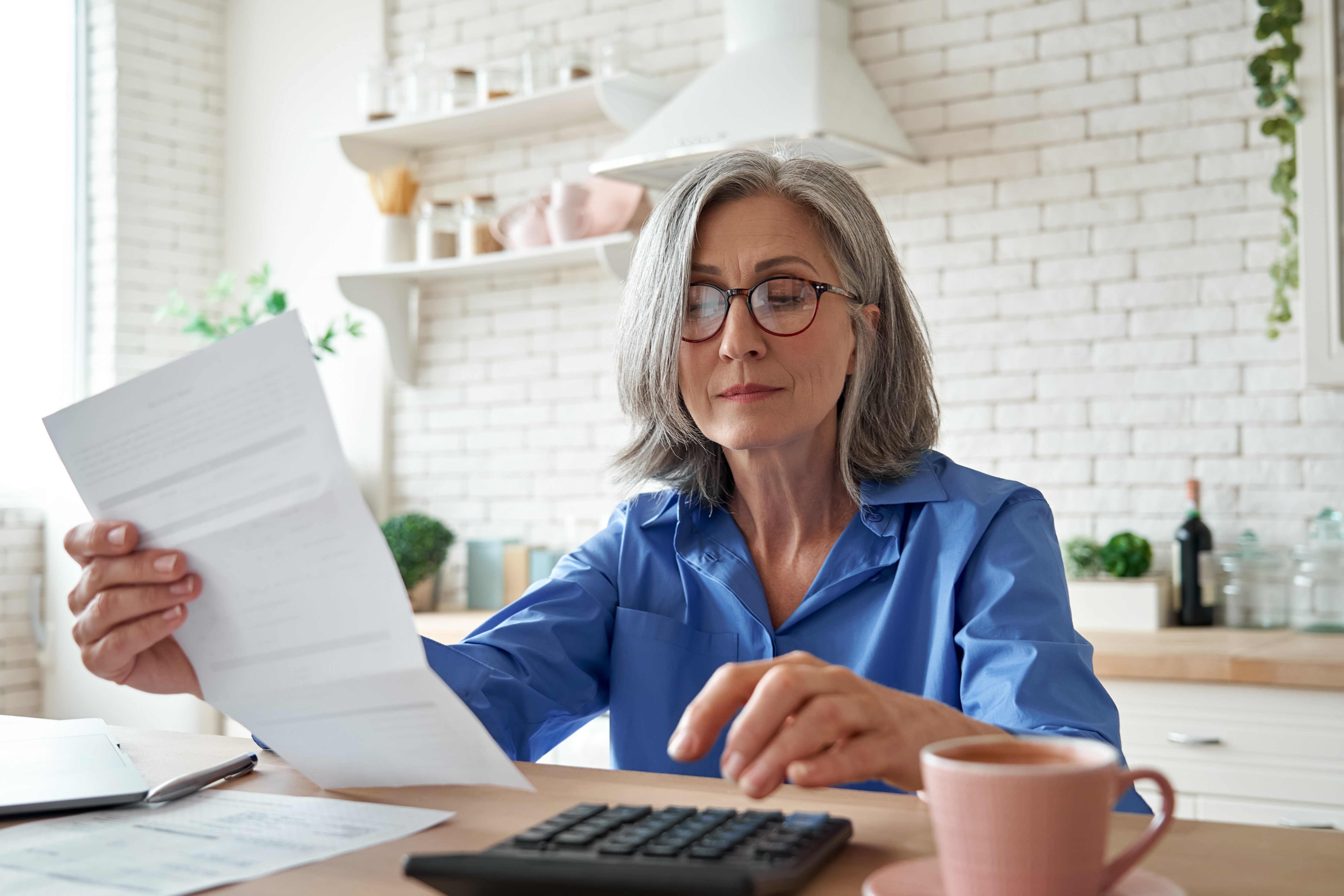 older lady reviewing documents and using calculator
