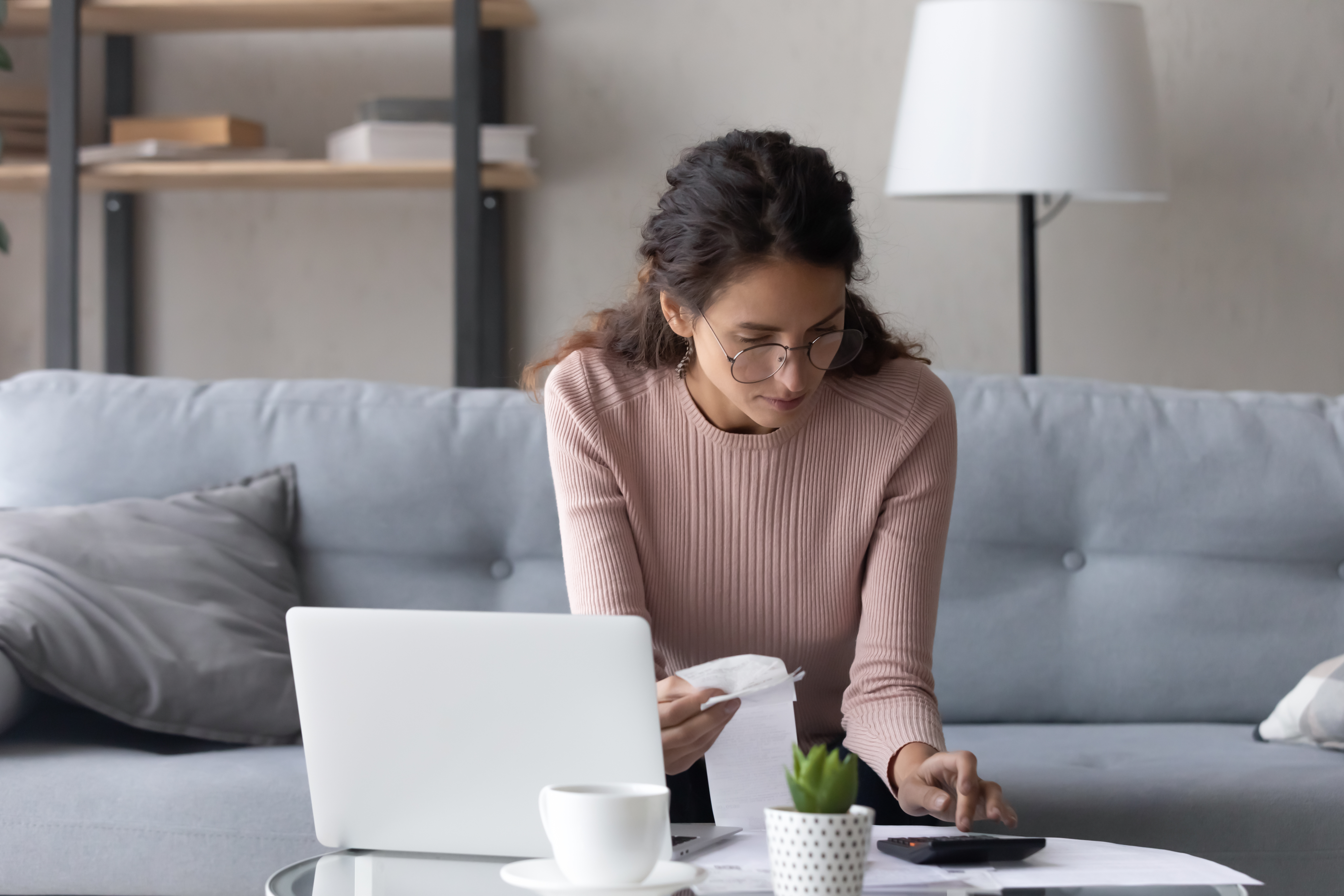 woman using calculator and laptop