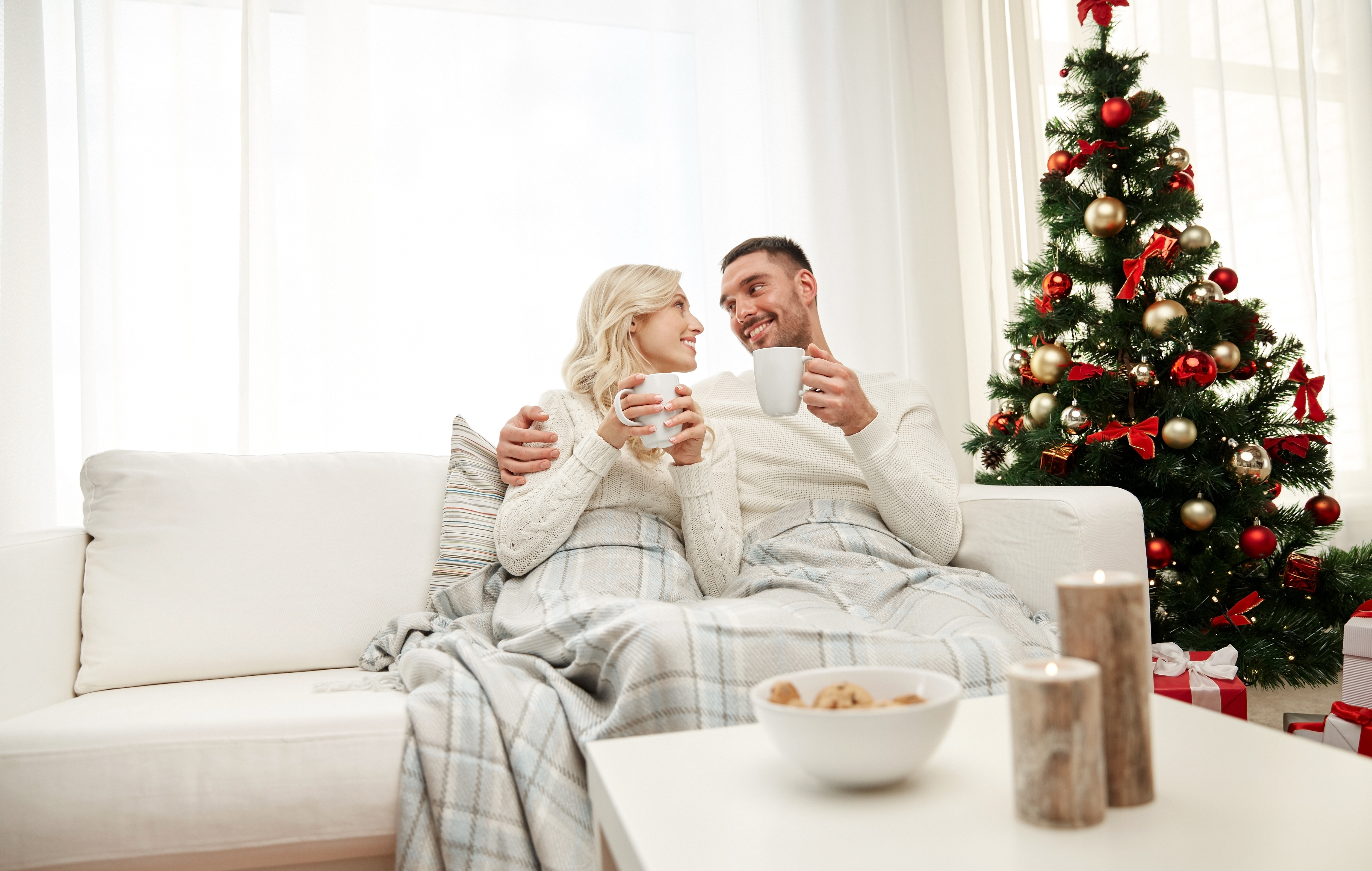Couple sitting on the couch by the Christmas tree