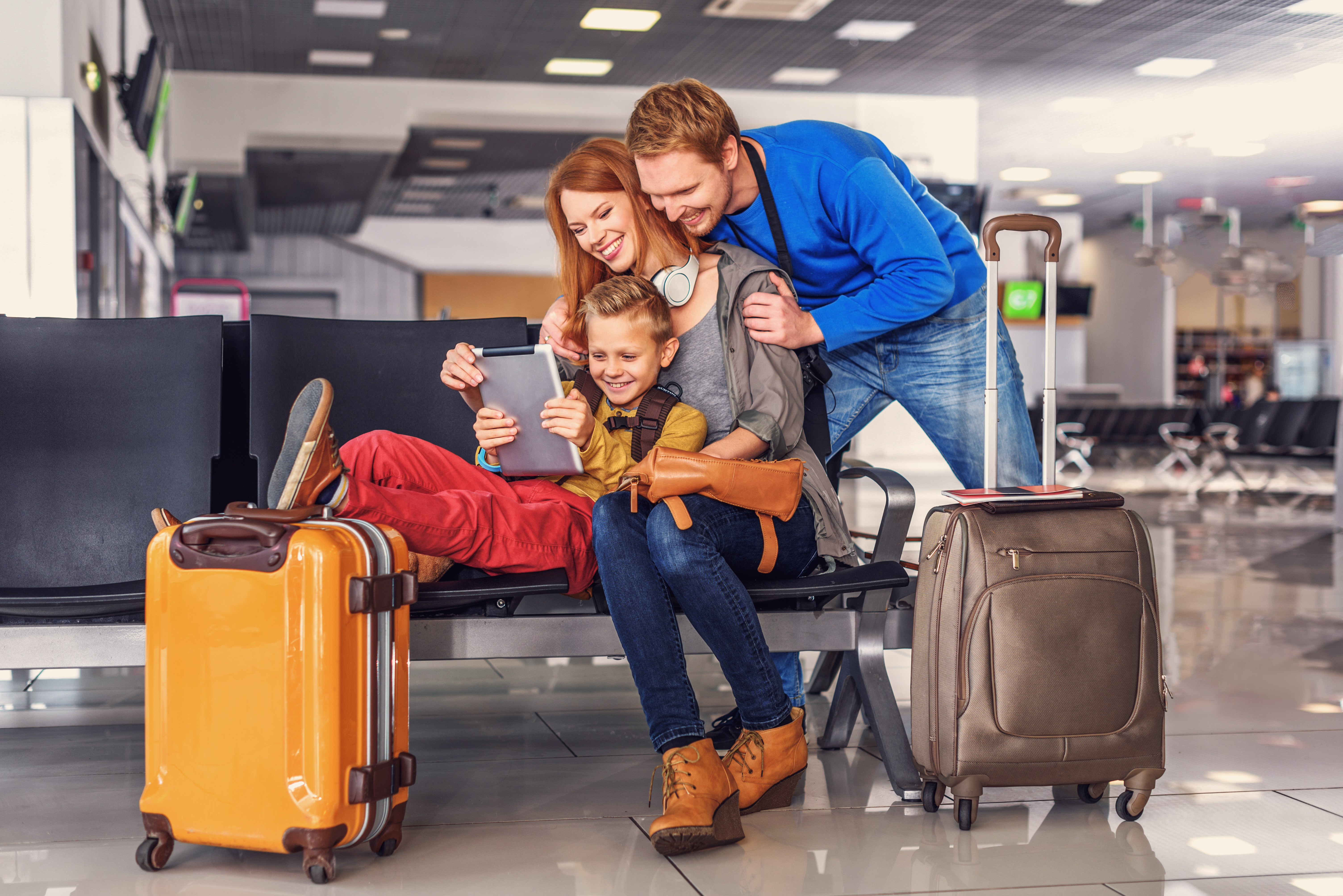 family sitting in an airport on an ipad 