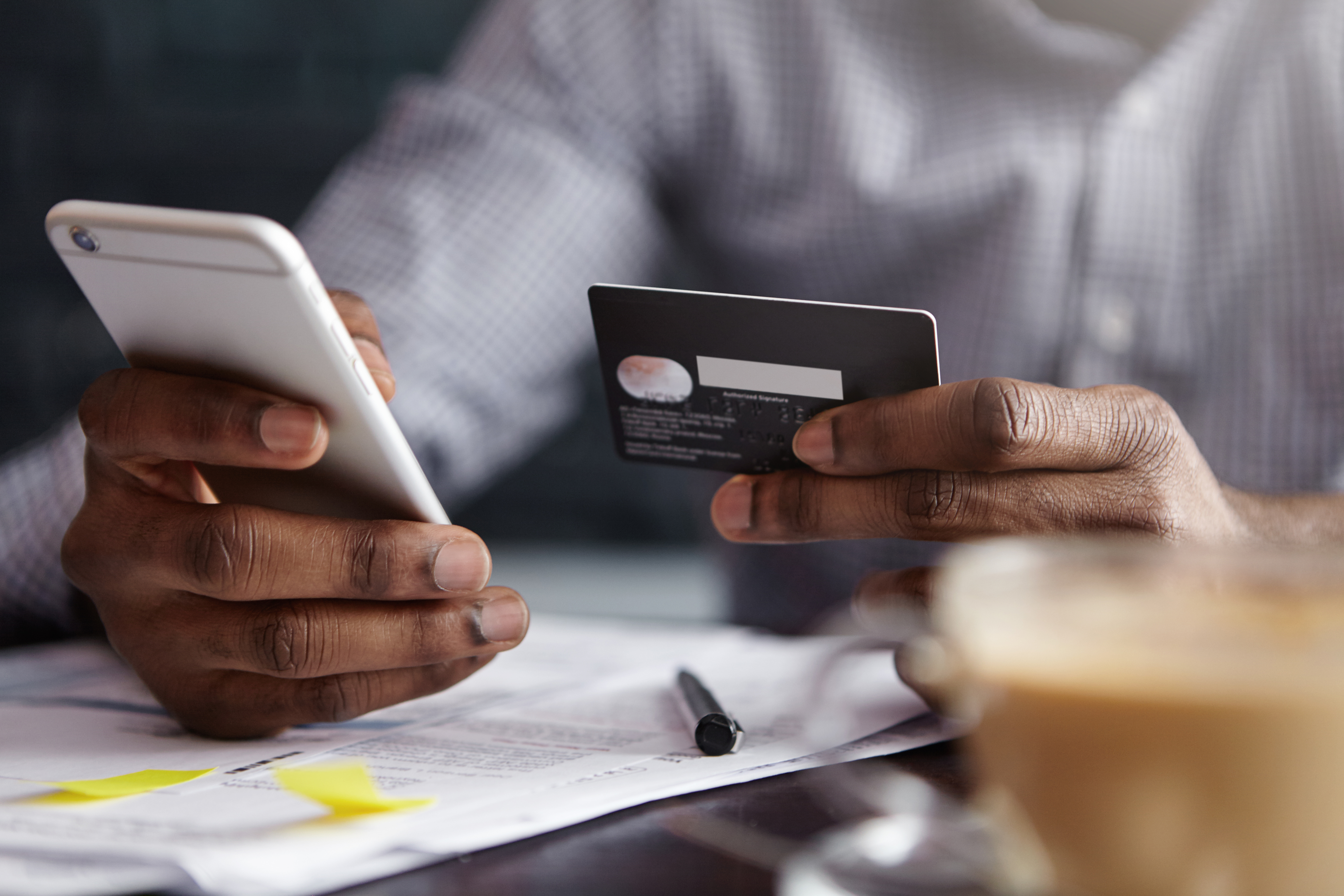 man holding credit card and phone