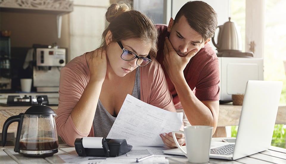 couple looking through water bill for an easy way to save money