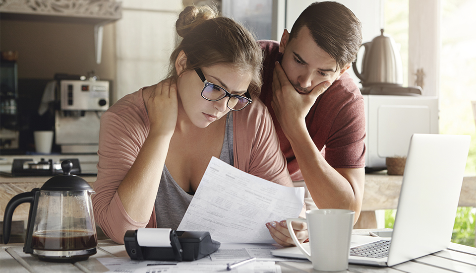 couple looking through water bill for an easy way to save money