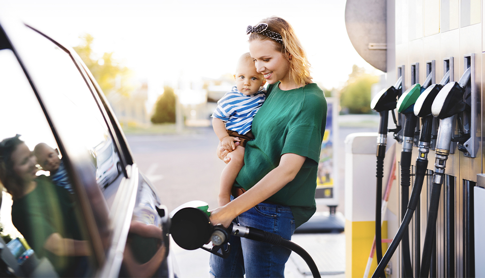 a mother and child saving money at the gas pump