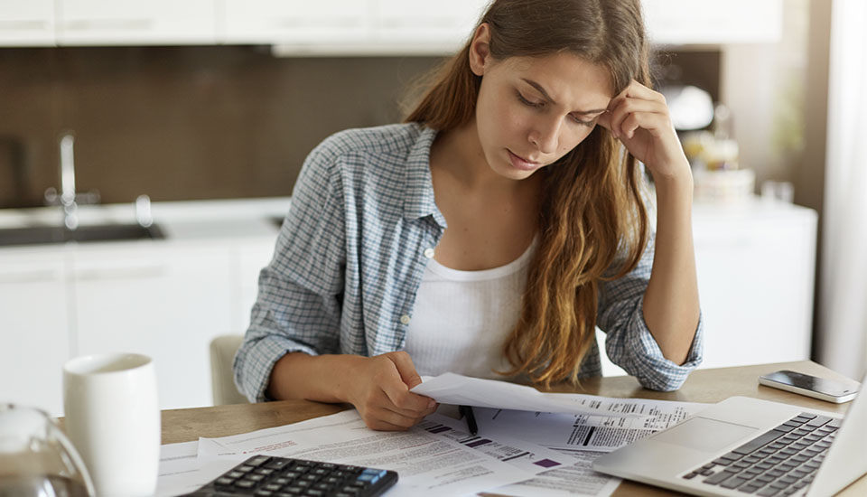 woman reviewing bills after her payday cycle changed