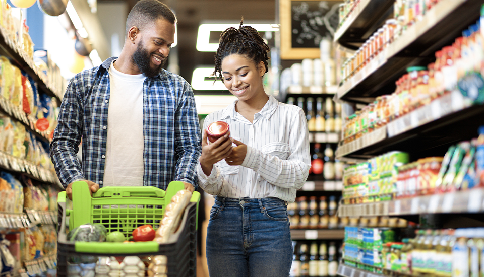 young black couple saving money while grocery shopping