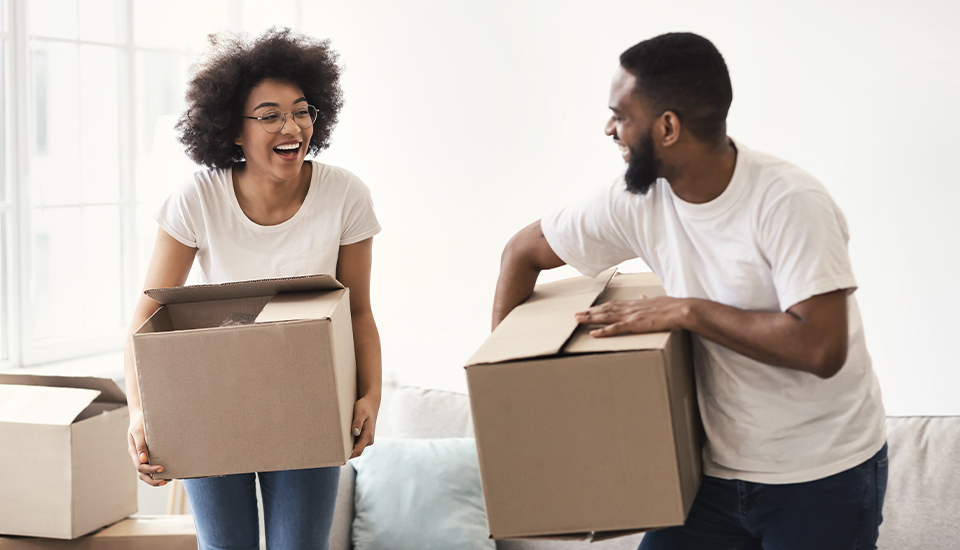 young home buyers with moving boxes discussing different mortgage loan options